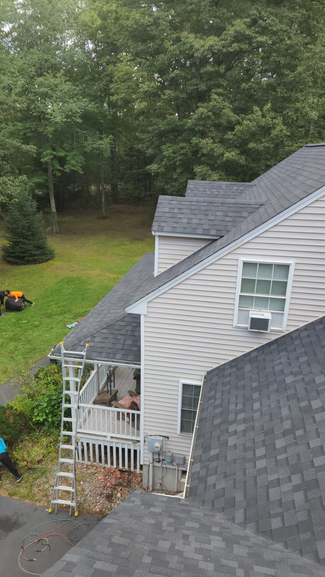 Rear slopes of the Wells home with new shingles, ladder still set at the eave