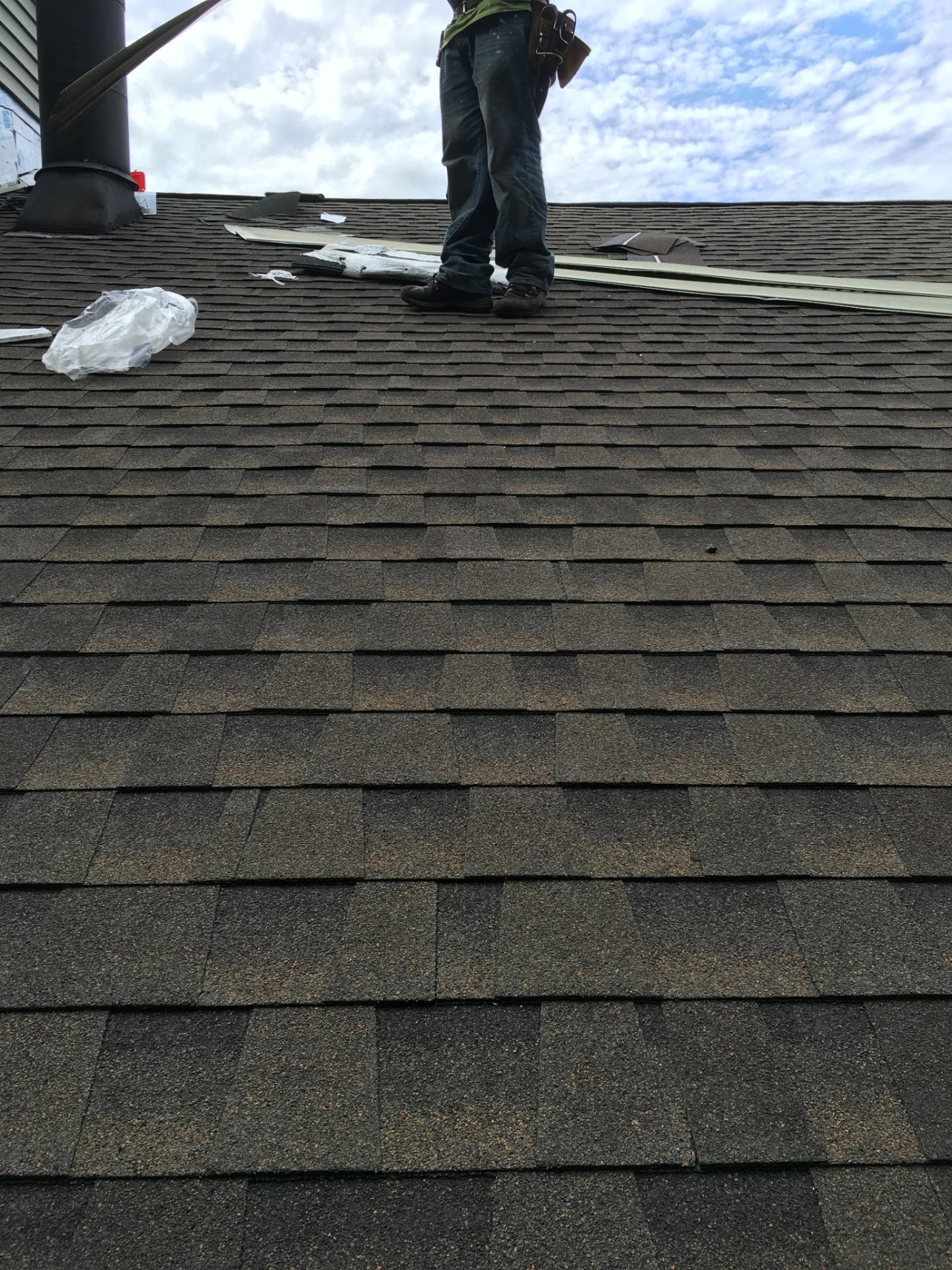 Detail of newly installed architectural shingles running up the slope