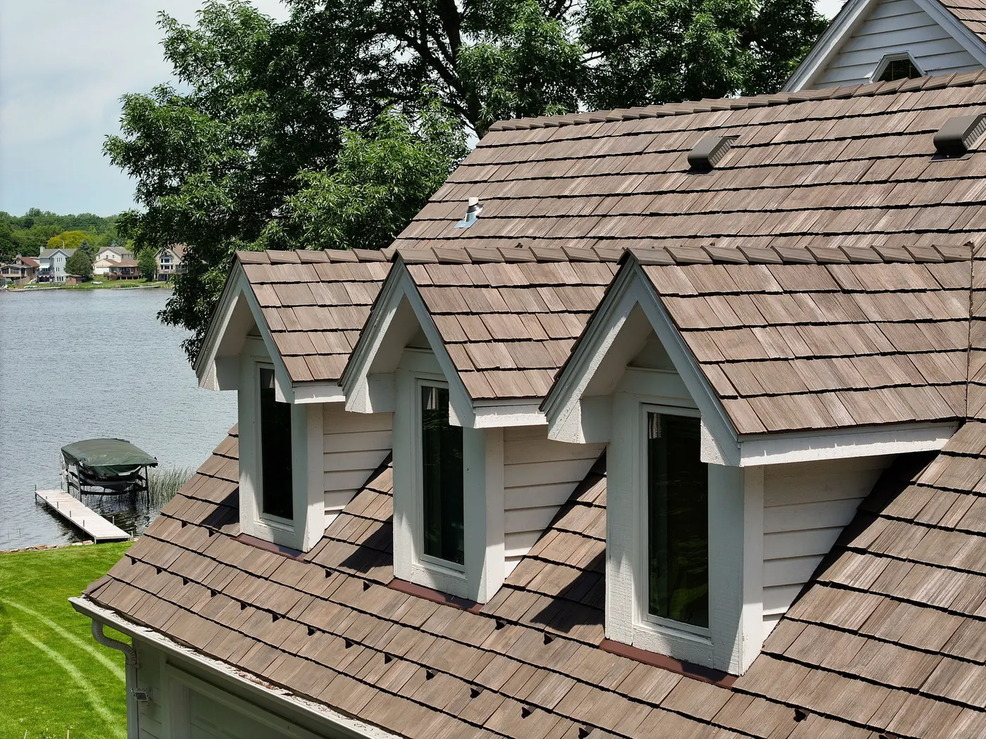 Brava composite cedar shake roof with varied tile widths installed around three dormers