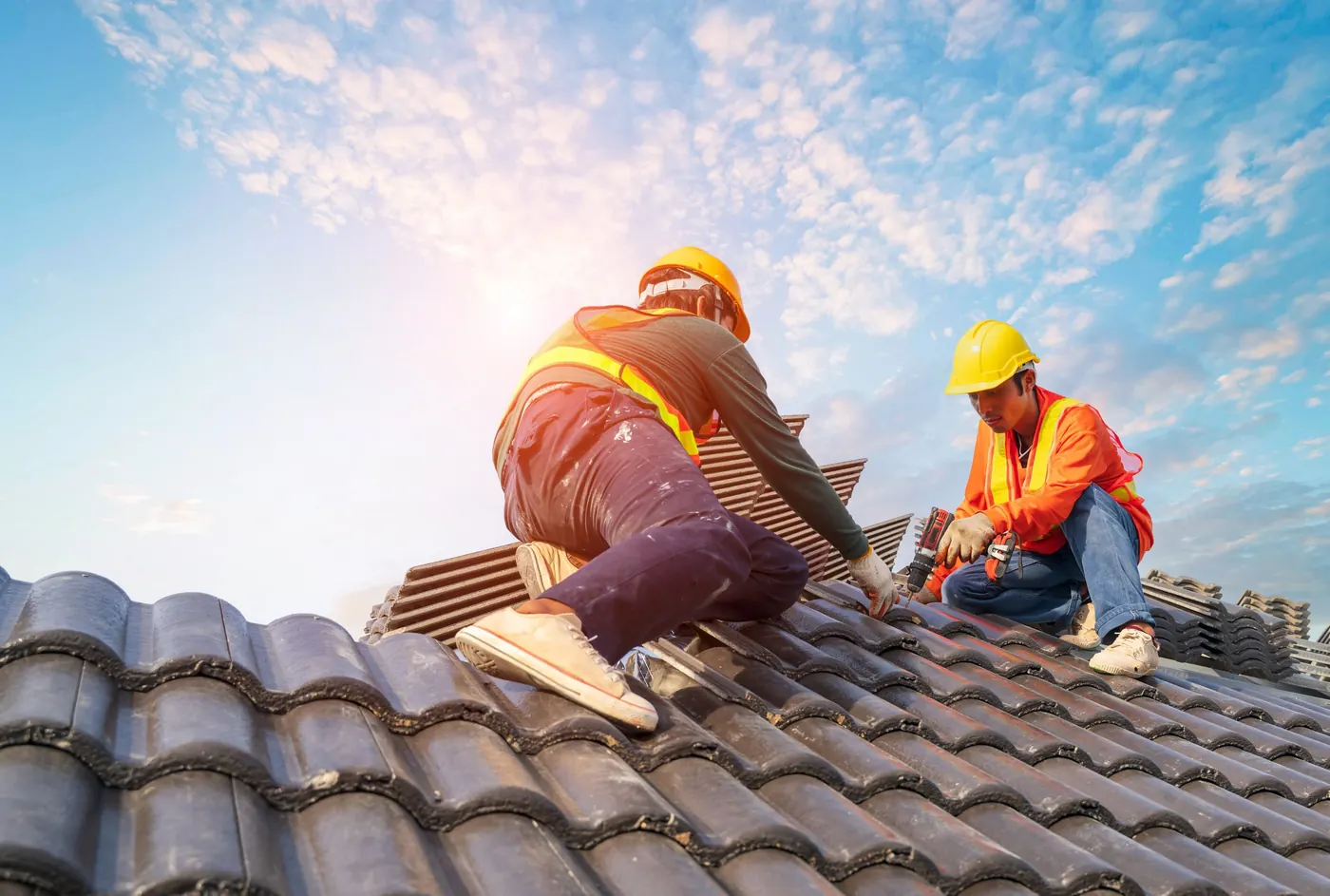 Roofing crew installing dark blended Brava Spanish Barrel Tile in interlocking courses