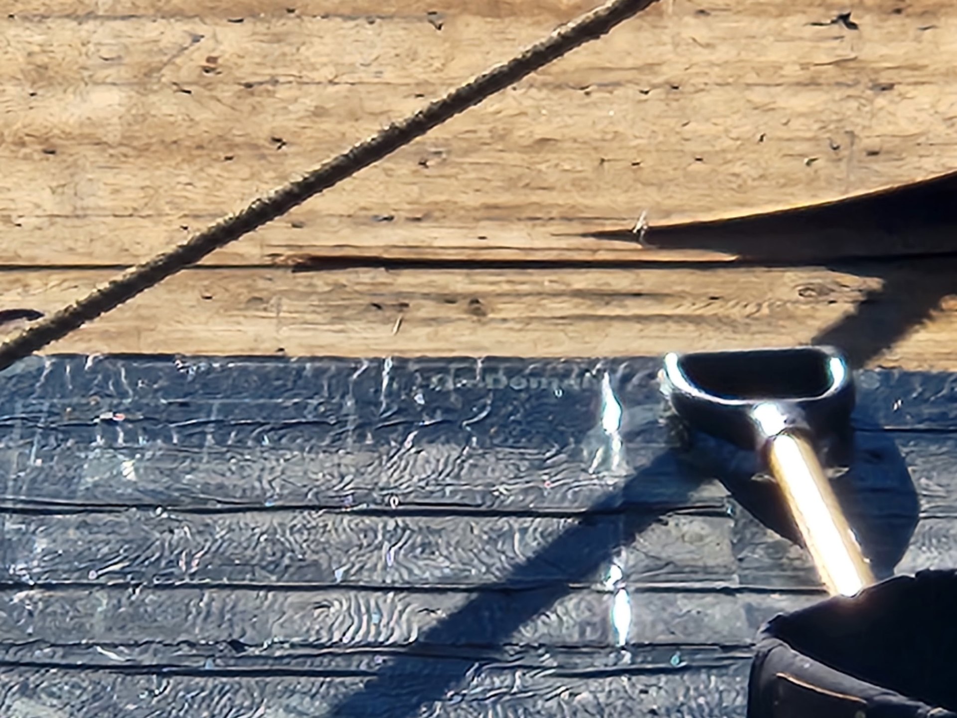 Close-up of ice-and-water shield membrane being set on the roof deck